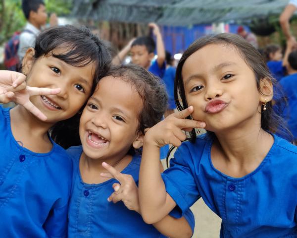 3 enfants des paillotes habillés en bleu pose devant la caméra