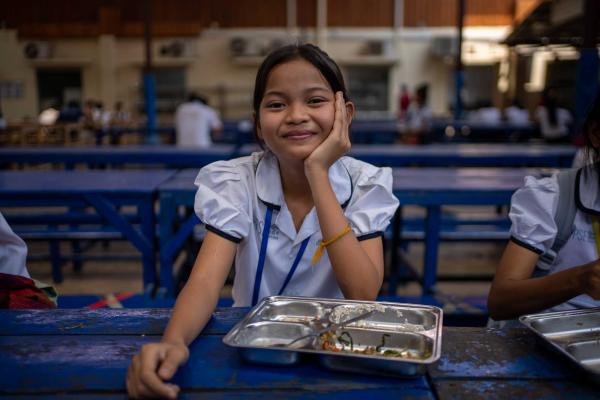 Une petite fille assise à la cantine après avoir terminé son repas