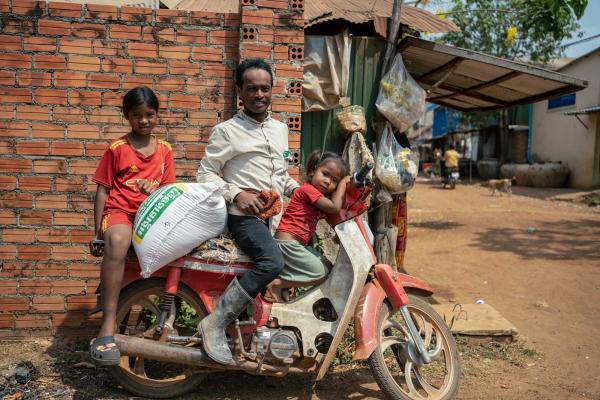 Une famille dans une communauté après avoir récupéré son sac de riz