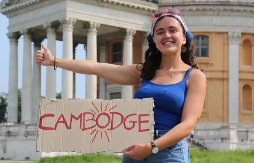 Lisa fait du stop en tenant un panneau Cambodge